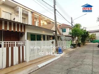 Suburban two-story home with secure gate and sheltered carport