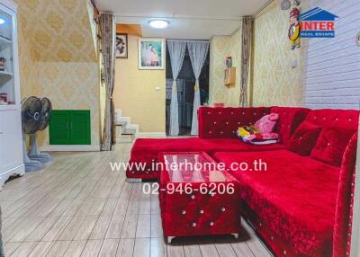 Cozy living room with red sofa and wooden flooring