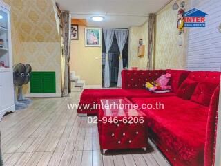 Cozy living room with red sofa and wooden flooring