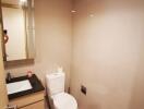 Modern bathroom with sleek design featuring a wall-mounted sink, mirror, and built-in toilet