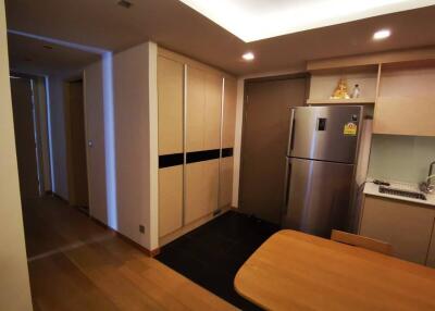 Modern compact kitchen with integrated appliances and wooden dining area