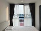 Bright bedroom with a large window and city view