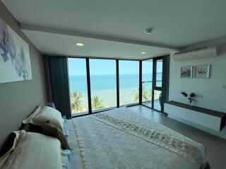 Ocean view bedroom with large windows and modern decor