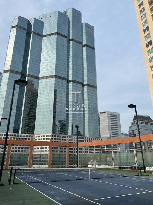 Modern skyscraper with tennis court in the foreground in urban area