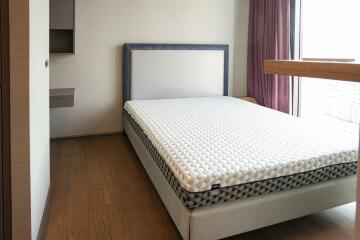 Modern bedroom with a large window and wooden flooring