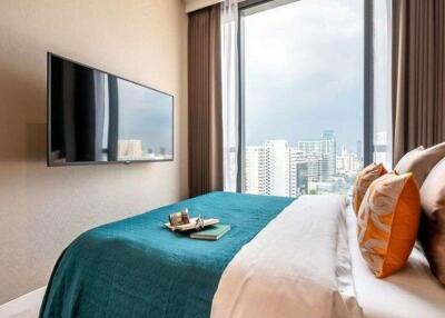 Modern bedroom with city view and mounted television