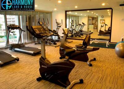 Well-equipped gym inside residential building with multiple exercise machines and mirrors