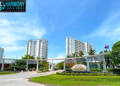 Exterior view of Harmony Land housing complex with lush greenery and clear blue sky