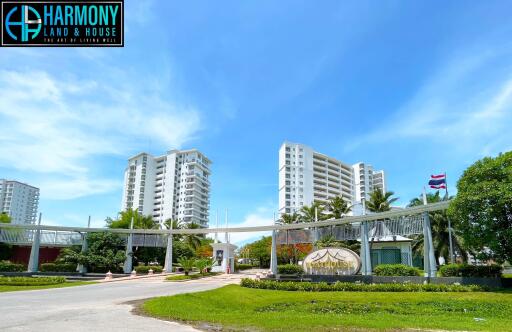 Exterior view of Harmony Land housing complex with lush greenery and clear blue sky