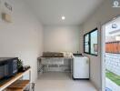 Modern small kitchen with stainless steel countertop and white walls