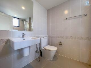 Modern bathroom with white fixtures and tiled walls