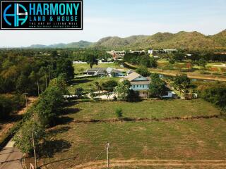 Aerial view of a residential property with green landscape and distant hills