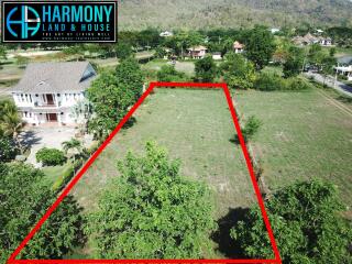 Aerial view of a large property with a spacious yard and a two-story house surrounded by lush greenery