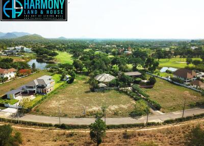 Aerial view of a spacious residential area with greenery and individual houses, suitable for property development