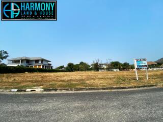 Spacious property for sale with large front yard and a single house in the background