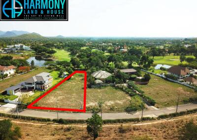 Aerial view of a spacious property for sale bordered by roads and neighboring homes with a scenic mountain backdrop