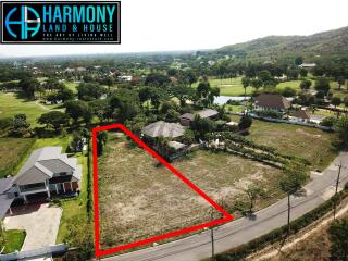 Aerial view of a residential lot ready for development with surrounding houses and lush scenery