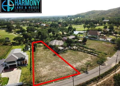 Aerial view of a residential lot ready for development with surrounding houses and lush scenery