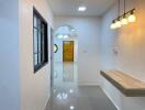 Elegant residential hallway with polished tile flooring, modern lighting, and wooden door