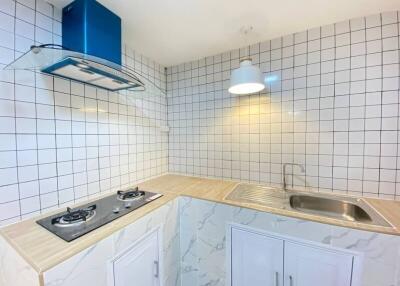 Modern kitchen with white tiled walls and natural light