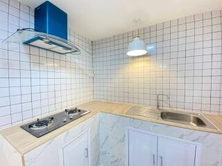 Modern kitchen with white tiled walls and natural light