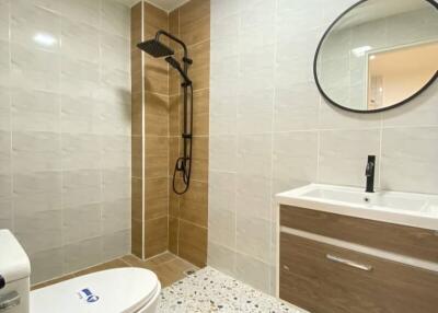 Modern bathroom with circular mirror and stylish tiling