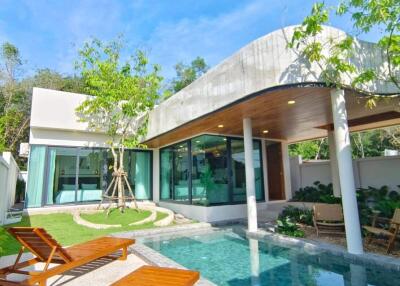 Luxurious backyard with a swimming pool, comfortable seating, and a modern house design