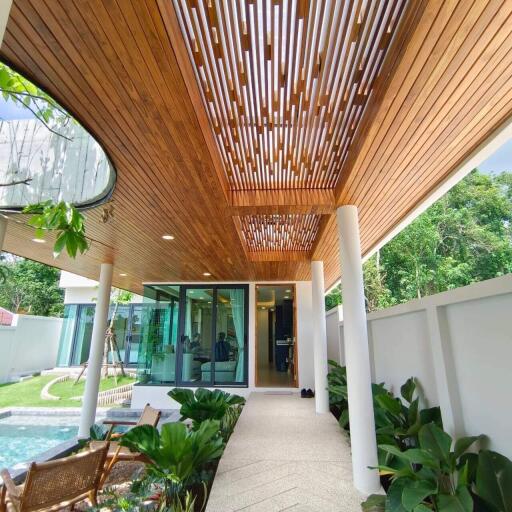 Stylish outdoor patio with wooden slatted ceiling and lush greenery