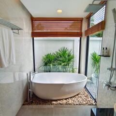 Modern bathroom with freestanding tub and natural views