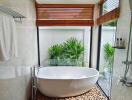 Modern bathroom with freestanding tub and natural views