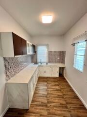 Modern kitchen with wooden flooring and mosaic backsplash