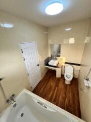 Spacious bathroom with modern fixtures and wooden flooring