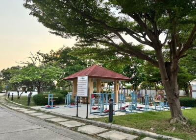 Outdoor fitness station in a park with lush green trees