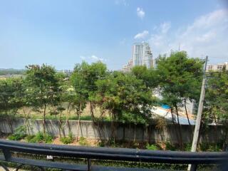 View from balcony showing nearby buildings and greenery