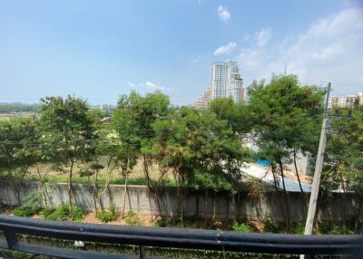 View from balcony showing nearby buildings and greenery
