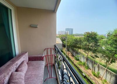 Spacious balcony with a plush sofa and a view of the surrounding cityscape