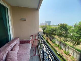 Spacious balcony with a plush sofa and a view of the surrounding cityscape