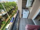Apartment balcony with a view of the street and outdoor washing machine