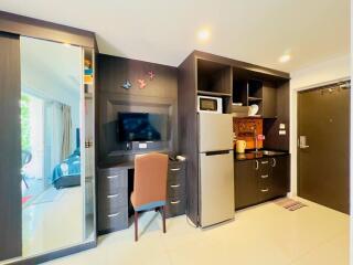 Compact modern kitchen with integrated appliances and adjacent bedroom view