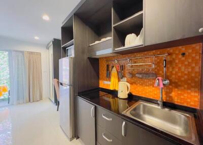Modern kitchen with orange backsplash and stainless steel appliances