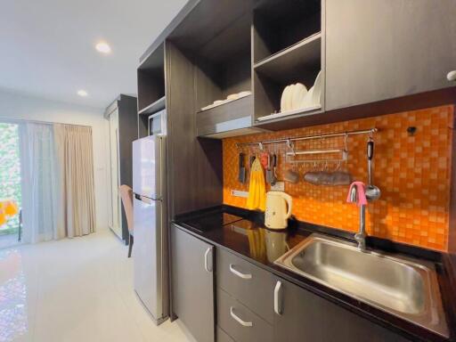 Modern kitchen with orange backsplash and stainless steel appliances