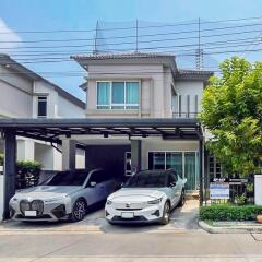 Modern two-story house with a double carport showcasing two cars