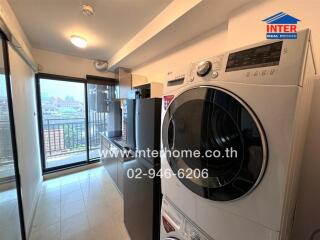 Compact laundry room with modern appliances and balcony access