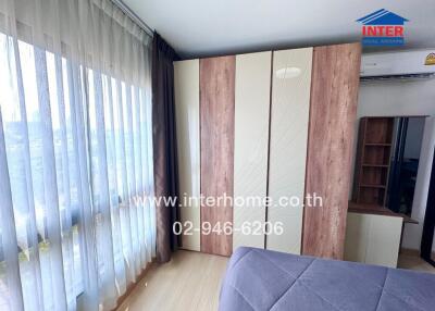 Bright and spacious bedroom with large windows and wooden wardrobe