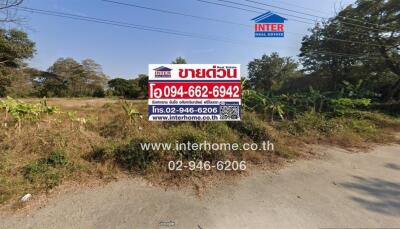 Real estate sign in front of vacant land