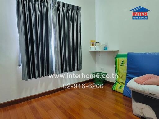Well-maintained bedroom with wooden flooring and natural lighting
