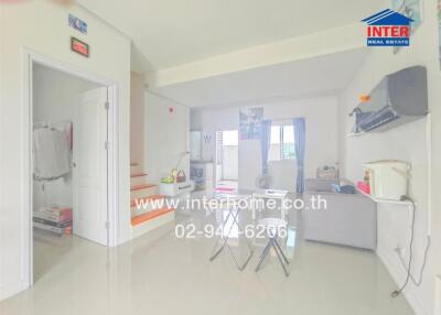 Spacious living room with open access to the kitchen area, well-lit interiors, and modern amenities