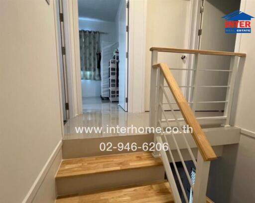 Bright corridor with wooden flooring leading to a well-lit room