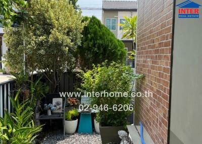 Well-maintained outdoor garden patio with lush greenery and seating area