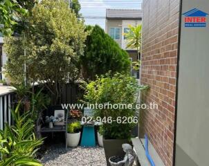 Well-maintained outdoor garden patio with lush greenery and seating area